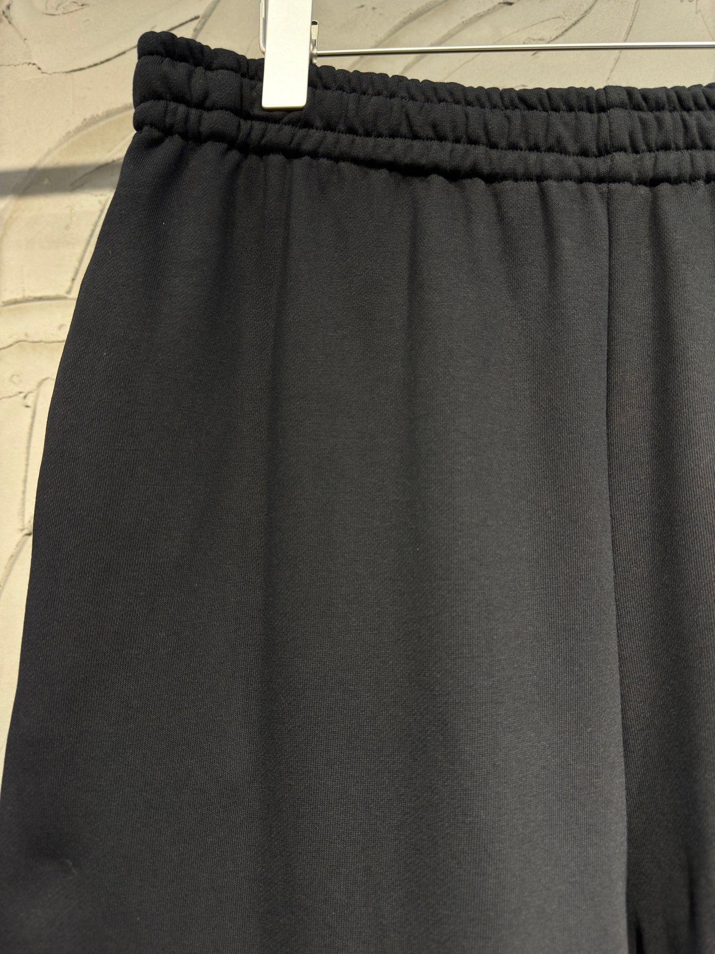 Black wide-leg pants with elastic waistband and smooth draped front