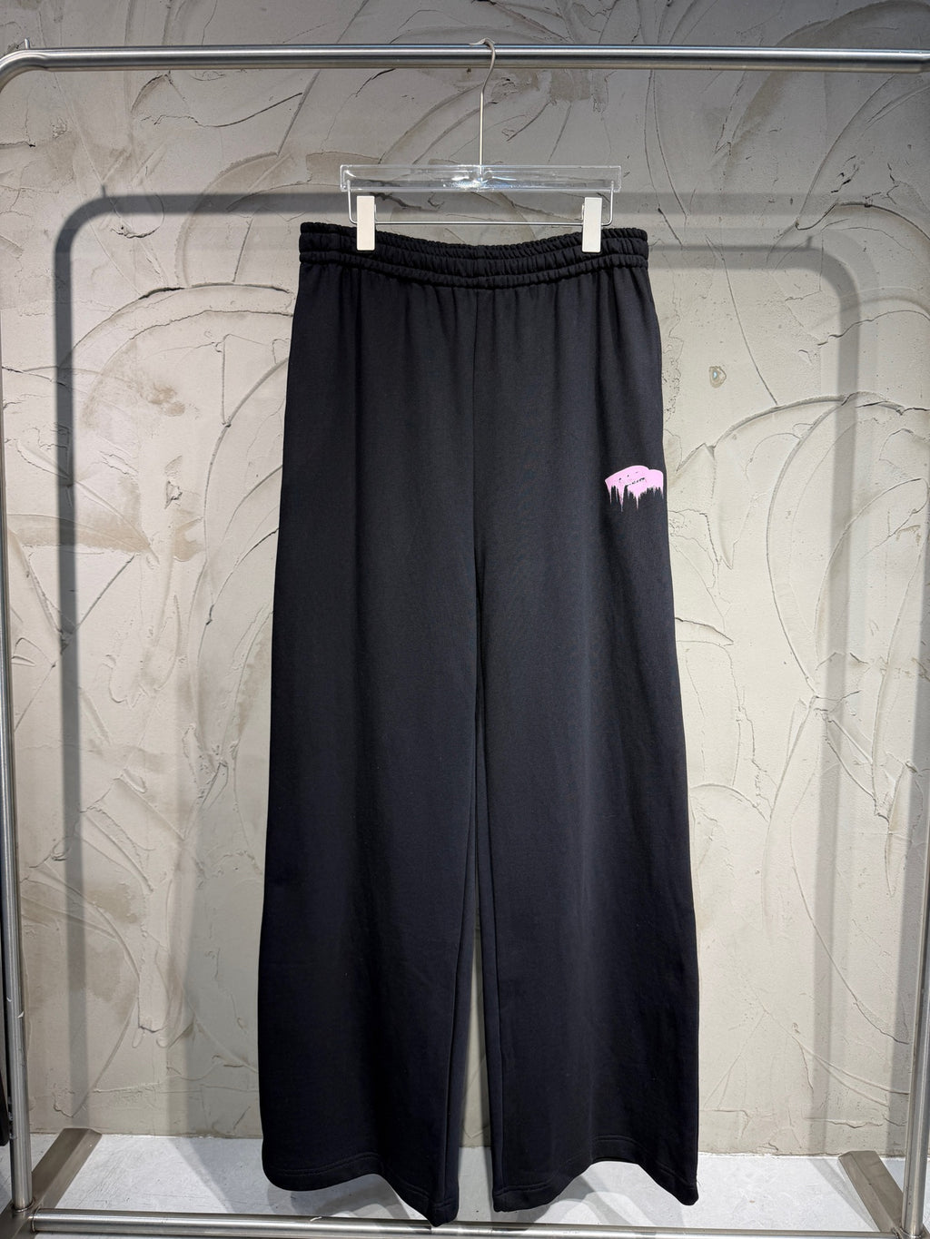 Balenciaga black wide-leg sweatpants with elastic waistband and pink graphic patch