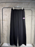 Balenciaga black wide-leg sweatpants with elastic waistband and pink graphic patch