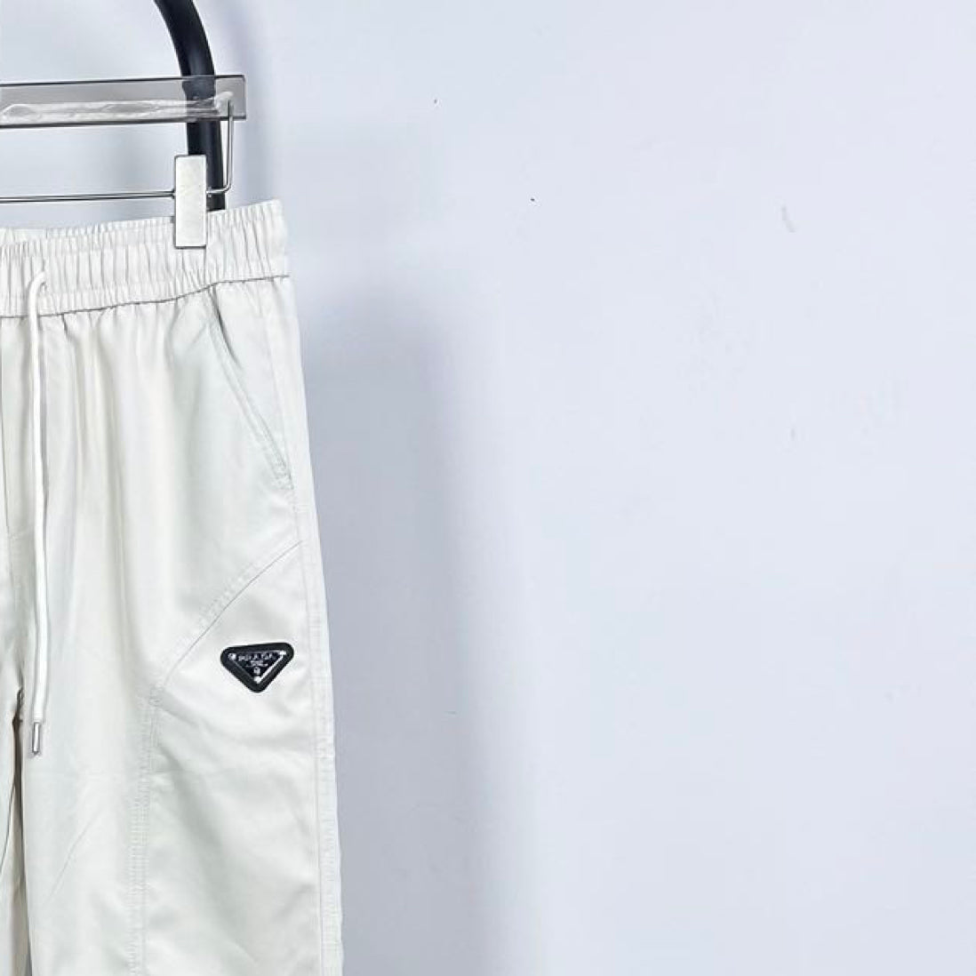 Prada white pants with triangle logo patch, elastic waist and drawstring