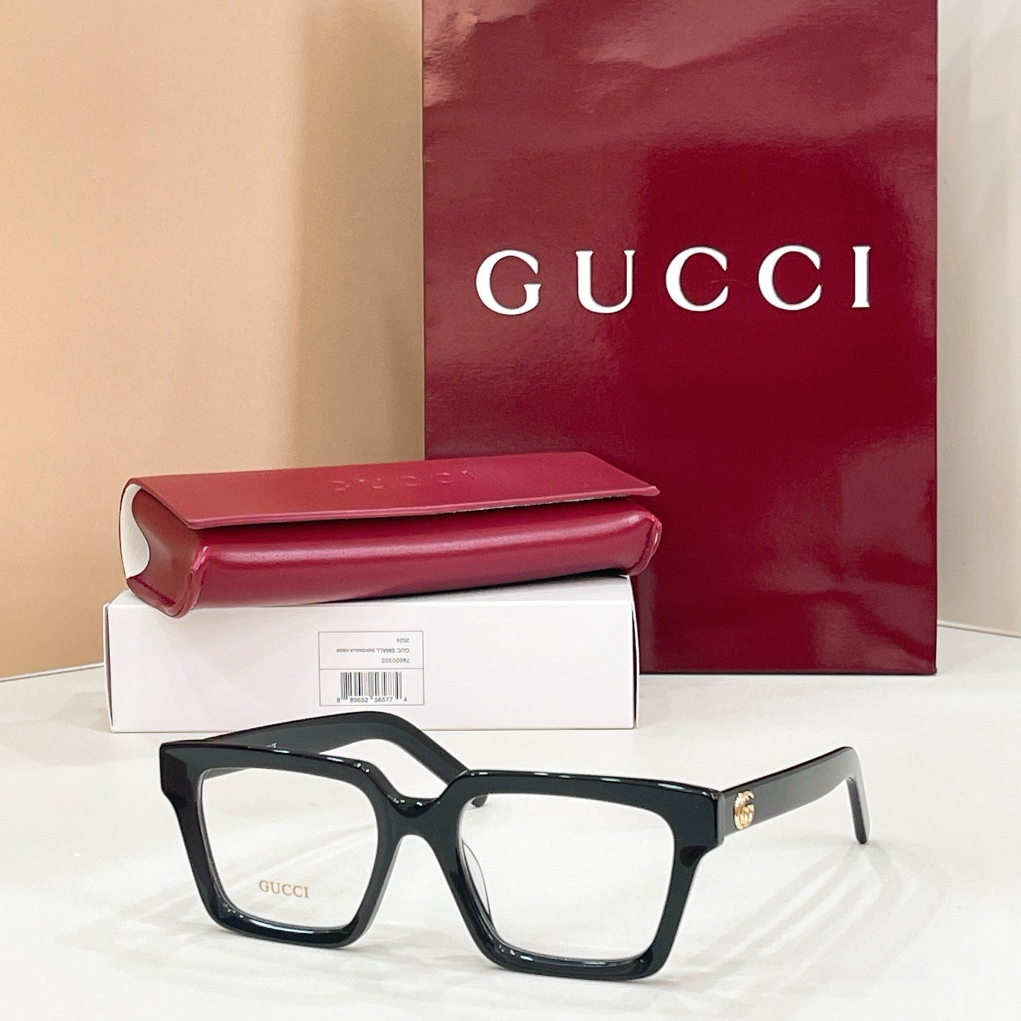 Rectangular eyeglasses with dark frame and clear lenses, subtle gold-tone temple detail