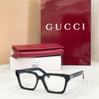 Rectangular eyeglasses with dark blue frame and clear lenses, gold-tone temple emblem