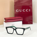 Rectangular eyeglasses with dark frame and light lenses, with green-accent temple tips