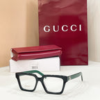 Rectangular eyeglasses with dark frame and light lenses, with green-accent temple tips