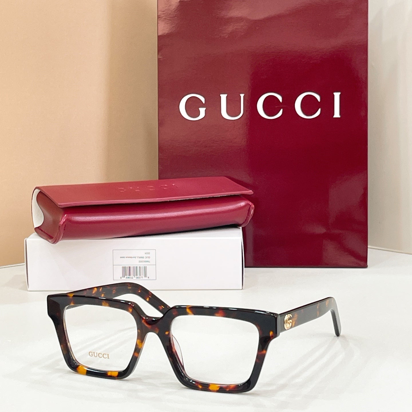Rectangular eyeglasses with dark frame and clear lenses, tortoiseshell temple pattern