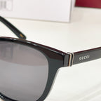 Gucci sunglasses with black frame, metal hinge, and lens close-up