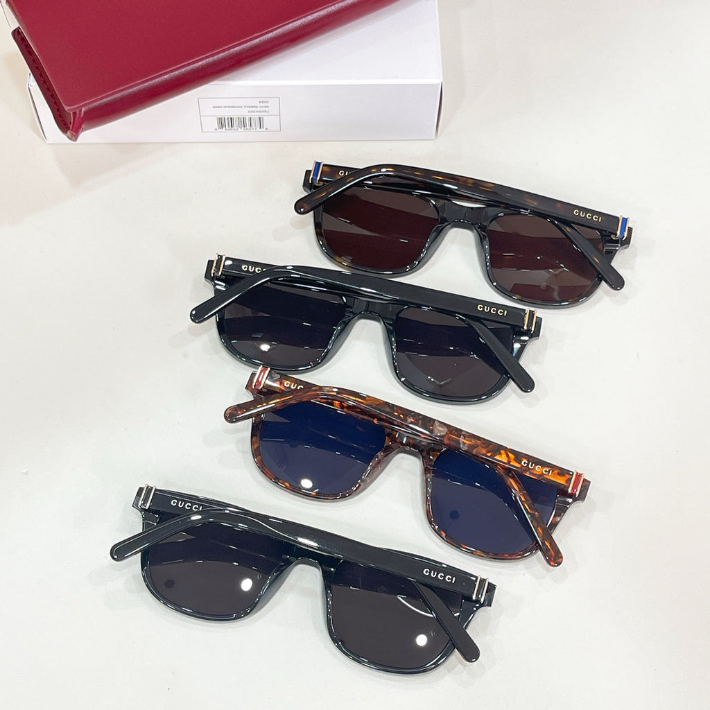 Set of four Gucci sunglasses with dark frames and blue-tinted lenses