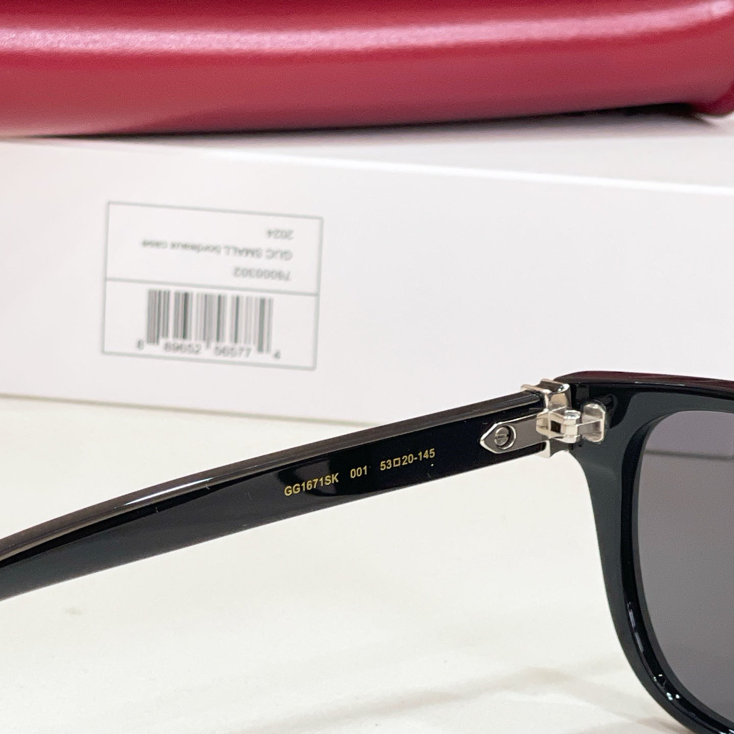 Gucci sunglasses side with black frame, metal hinge, and printed sizing