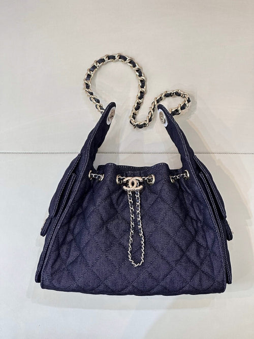 Chanel quilted dark blue bucket bag with chain handles and gold logo front