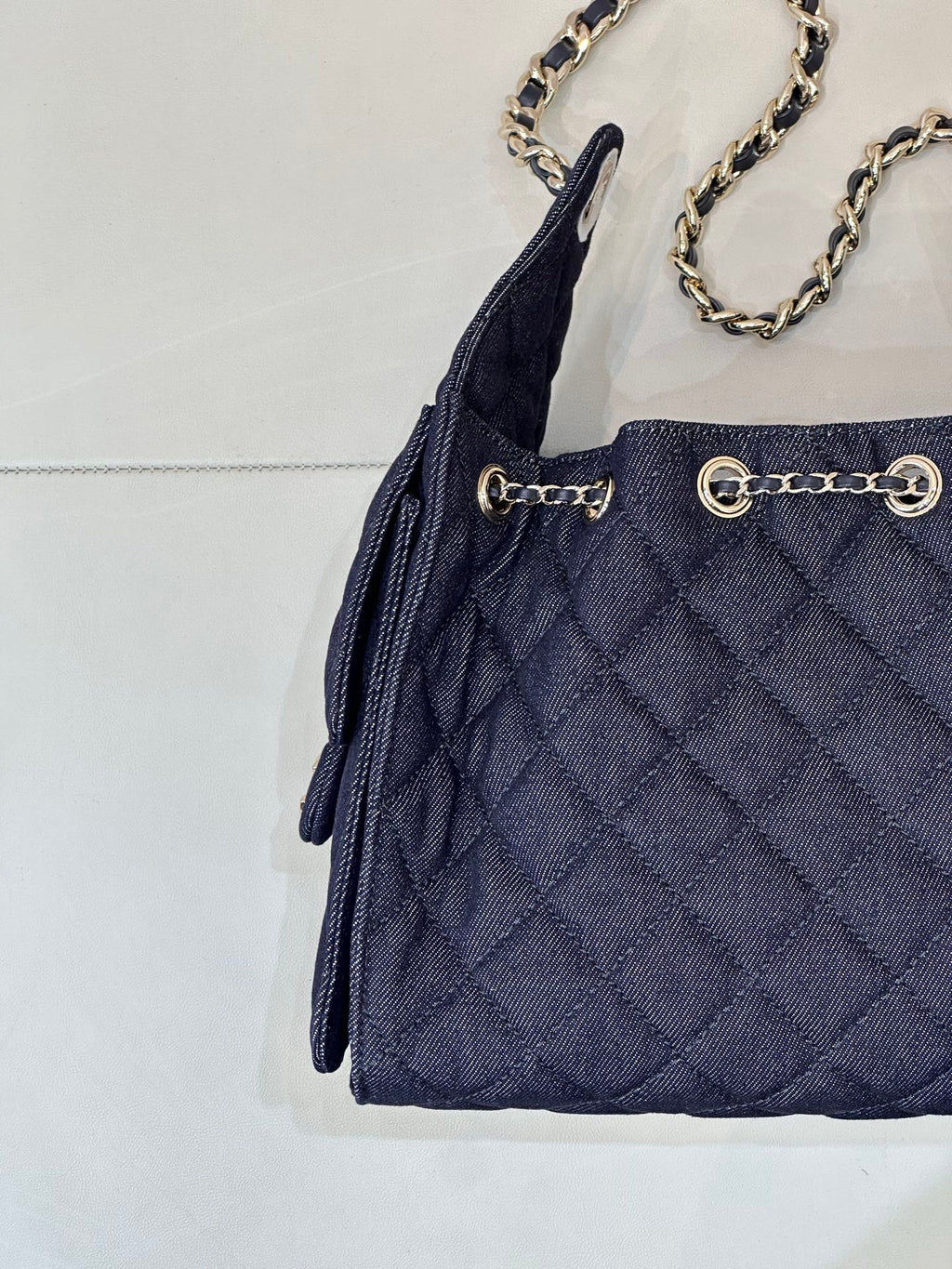 Chanel quilted dark blue bag front with grommet details and chain strap