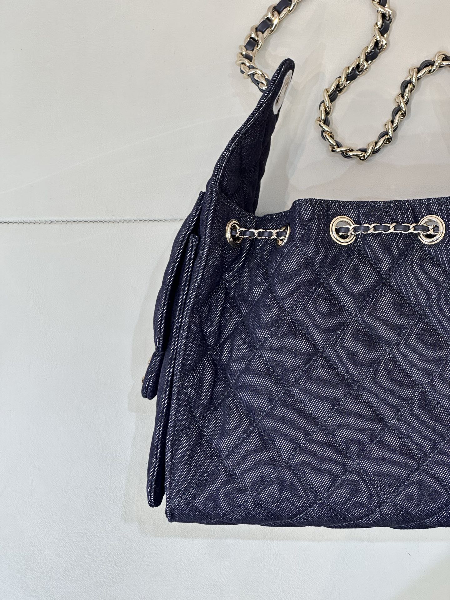Chanel quilted dark blue bag front with grommet details and chain strap