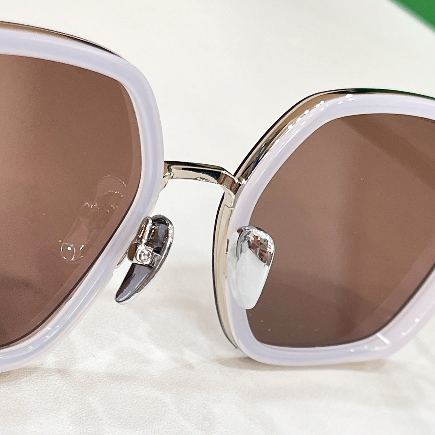 White-frame sunglasses with brown-tinted lenses, close-up