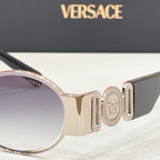Versace sunglasses close-up: gold-tone temple with Medusa-style emblem