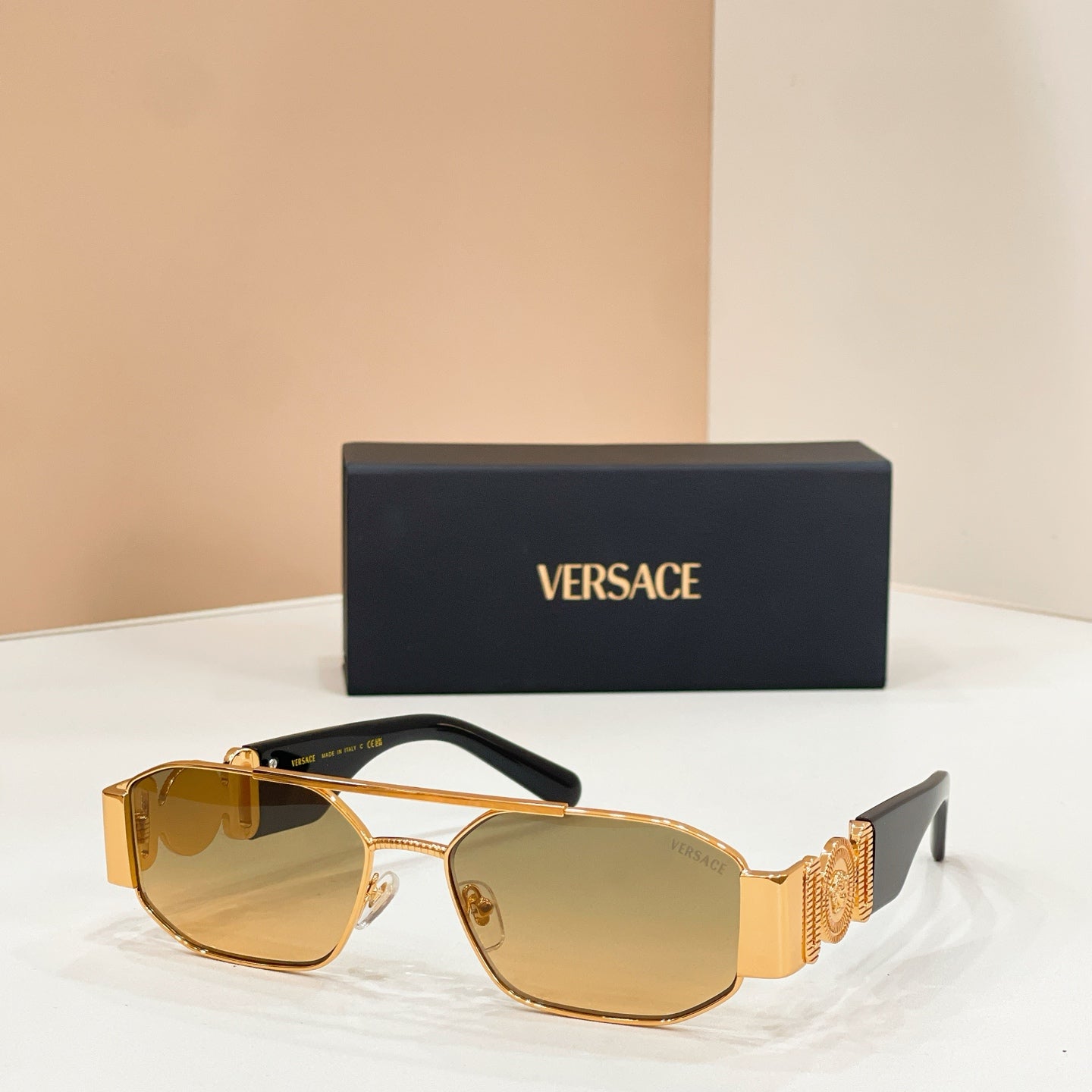 Versace sunglasses with amber lenses, gold frame, and logo temple arm detailing