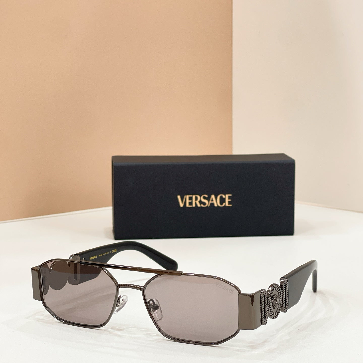 Versace sunglasses with dark lenses, silver frame, and logo temple details