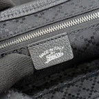 Gucci bag label with “MADE IN ITALY” on dark jacquard fabric near zipper