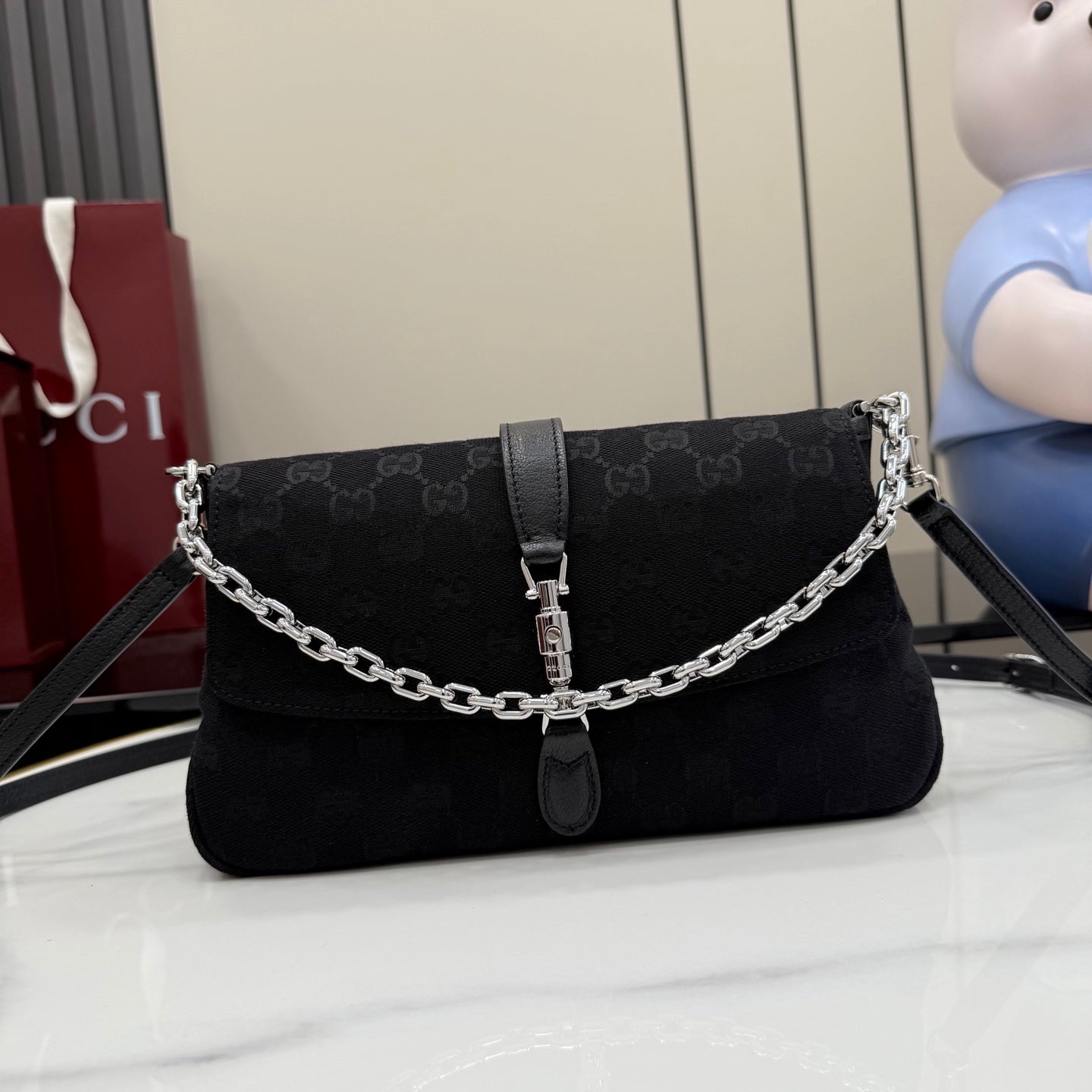 Gucci chain shoulder bag in black jacquard canvas with front flap and buckle strap