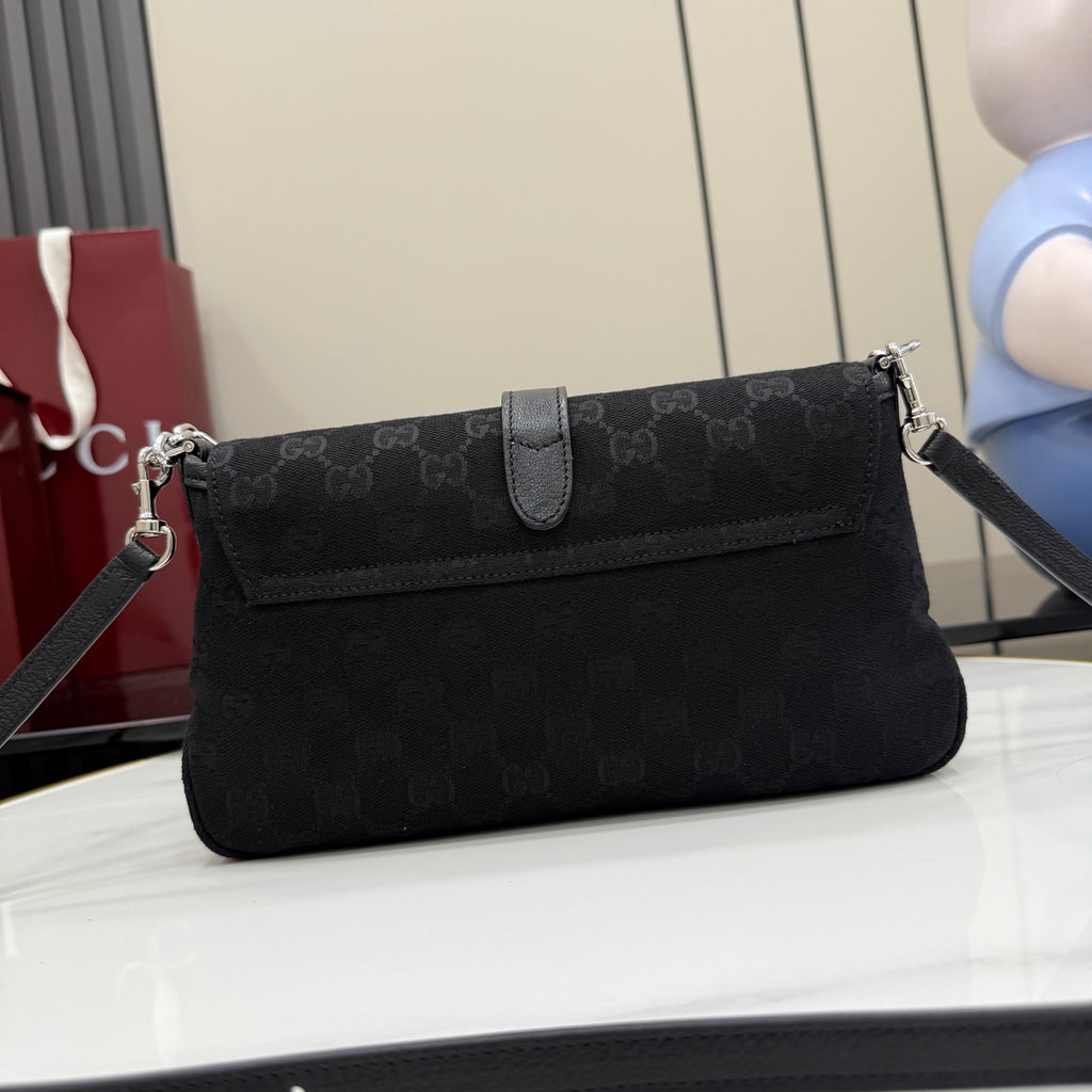 Gucci shoulder bag in black jacquard with front flap, buckle strap, and top chain detail