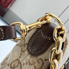Gucci bag close-up with gold-tone hardware, brown leather trim, and textured canvas.