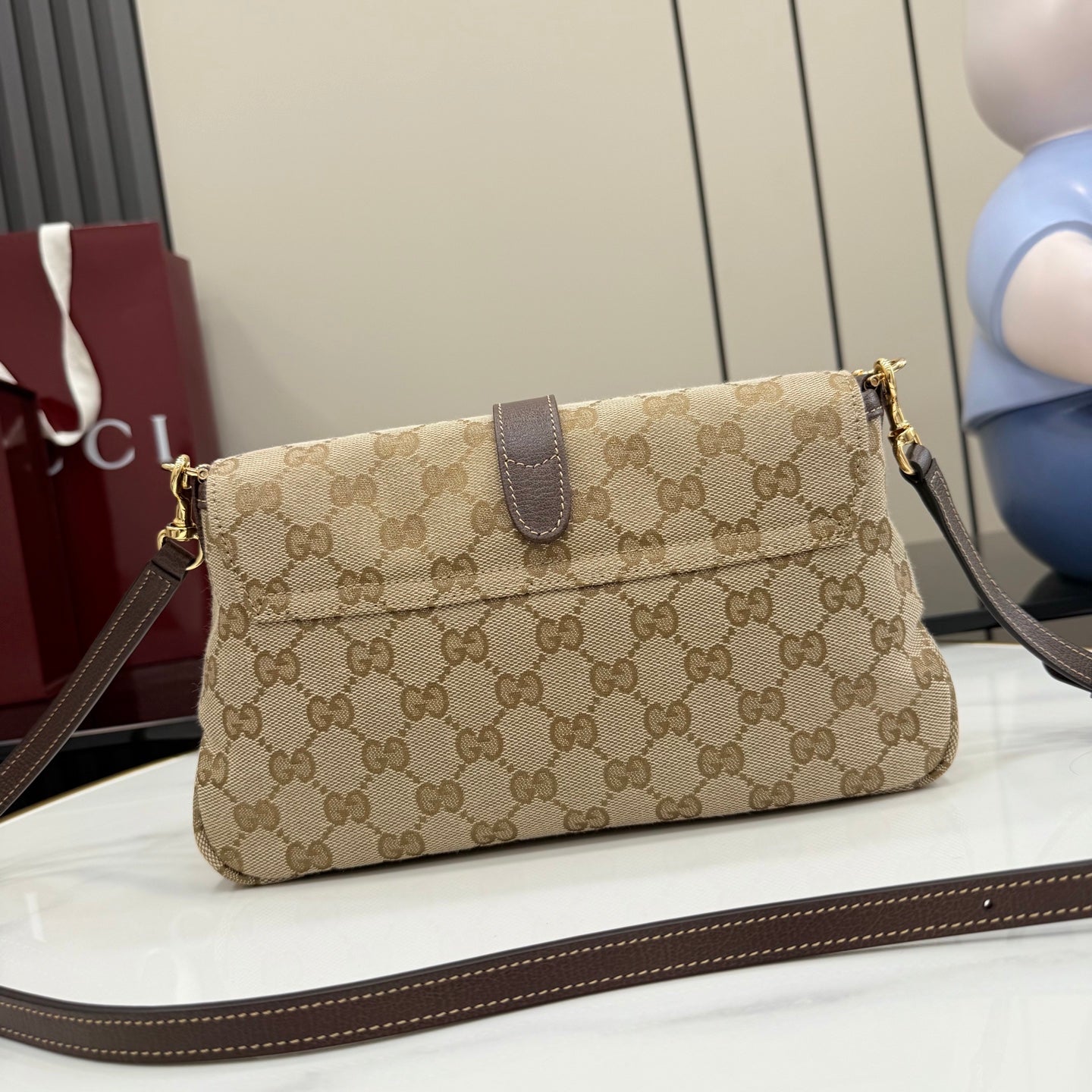 Beige GG canvas shoulder bag with brown leather strap and gold chain detail