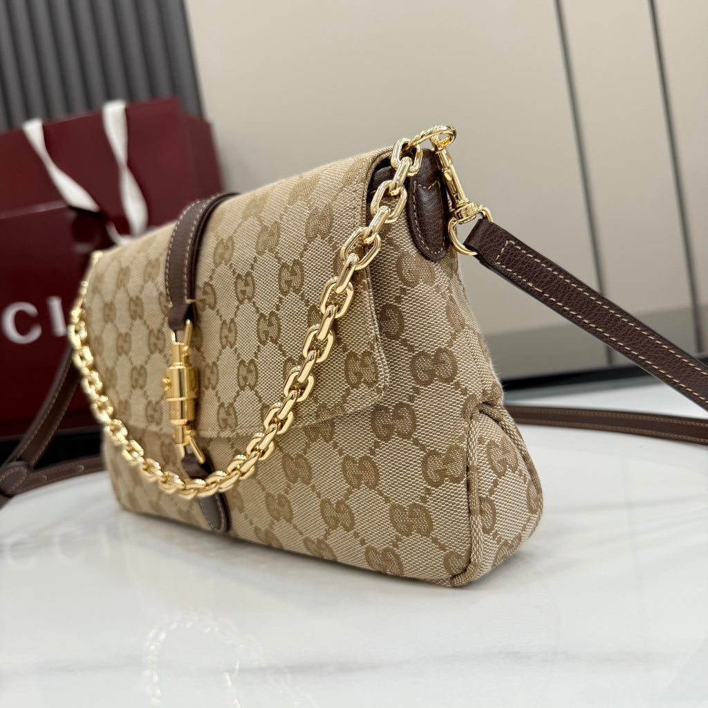 Beige GG canvas shoulder bag with gold chain strap and brown leather handle detail
