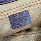 Embossed leather label inside the beige GG canvas bag with dark blue backing