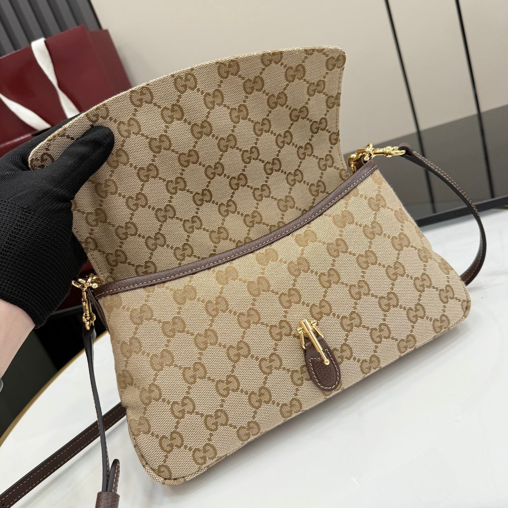 Beige GG canvas crossbody bag with brown leather strap, front pocket and gold hardware