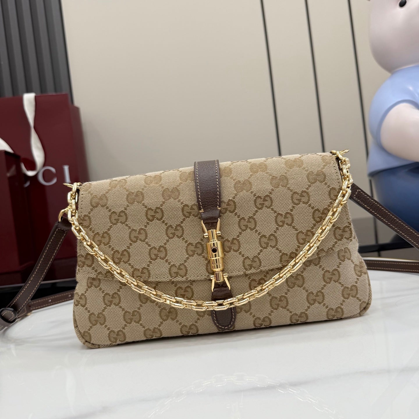 Gucci shoulder bag in beige GG canvas with brown leather trim and gold chain strap