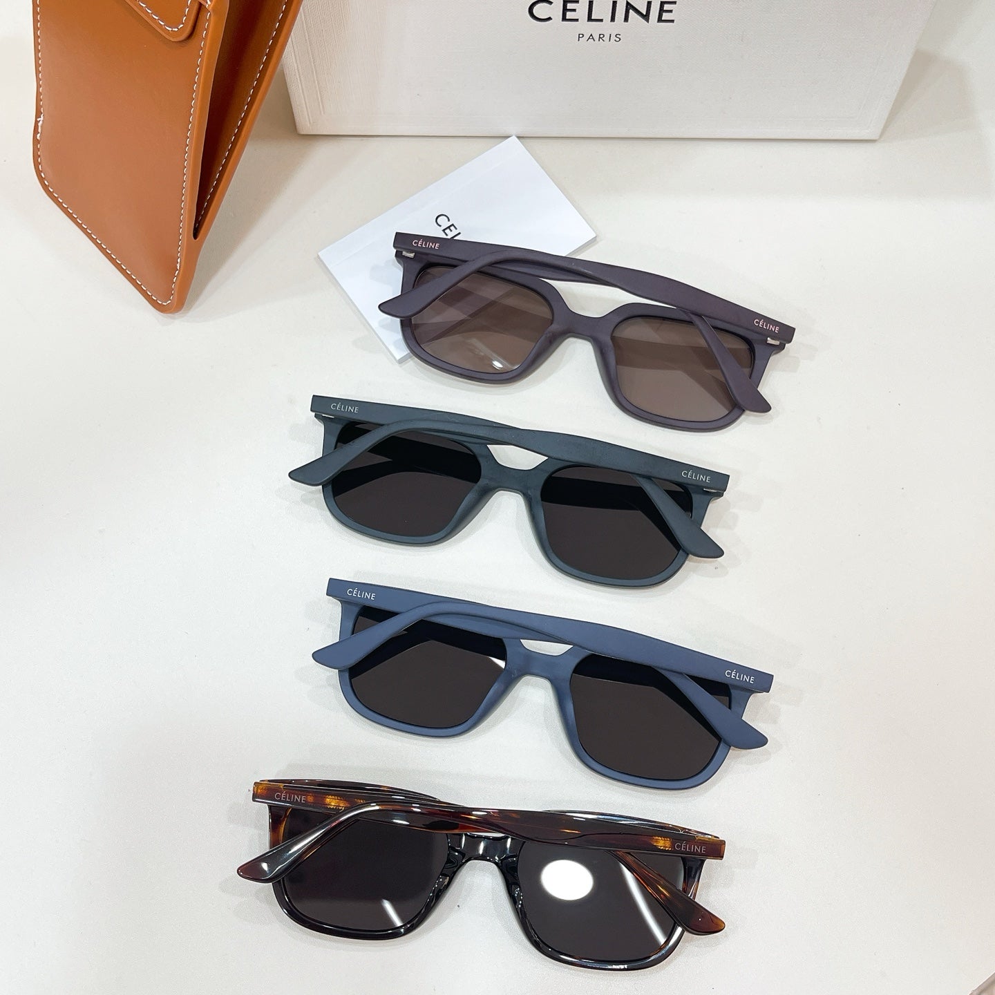Set of Celine sunglasses with navy and black frames, dark lenses, plus brown case.
