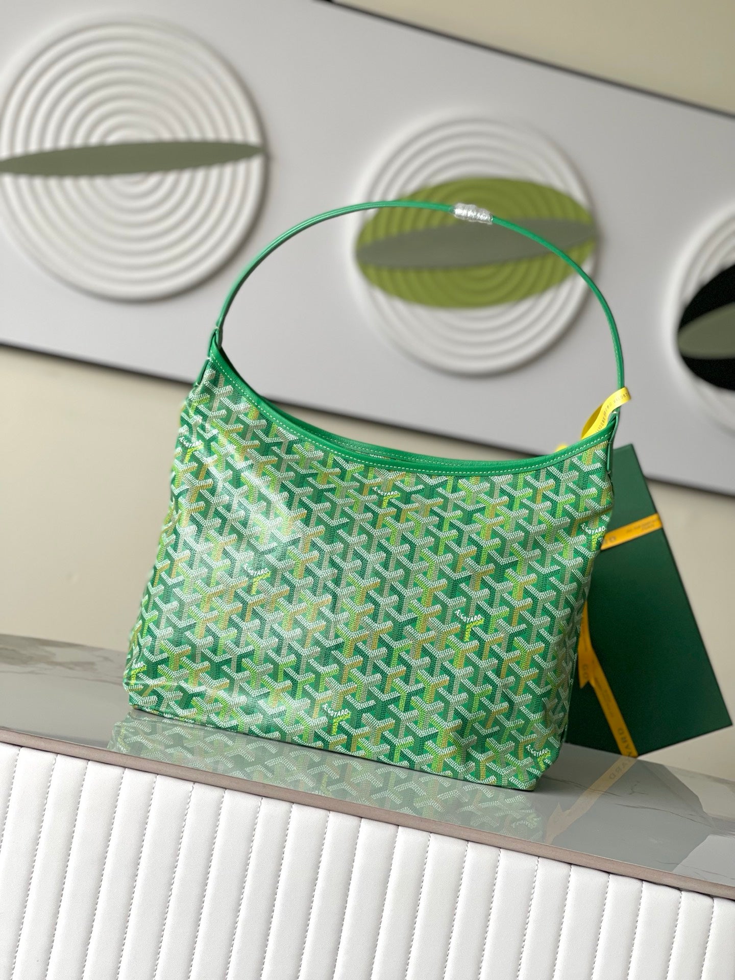 Green patterned shoulder handbag with top handle and curved strap