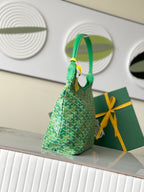 Green patterned handbag with short handles and hanging gold charm