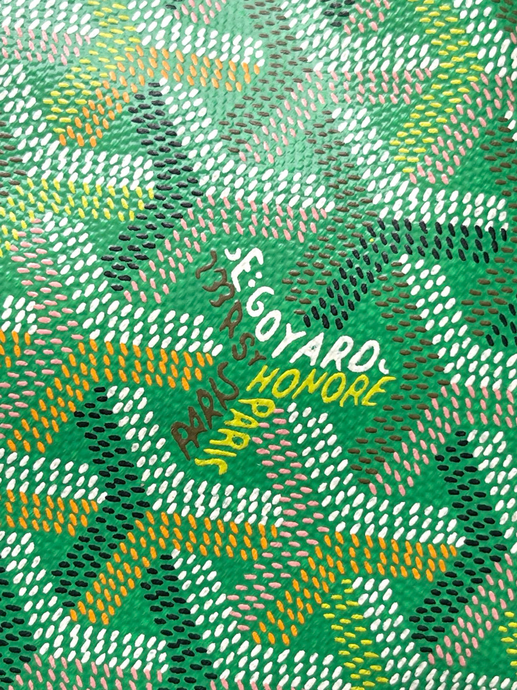 Close-up of green patterned fabric with GOYARD logo text
