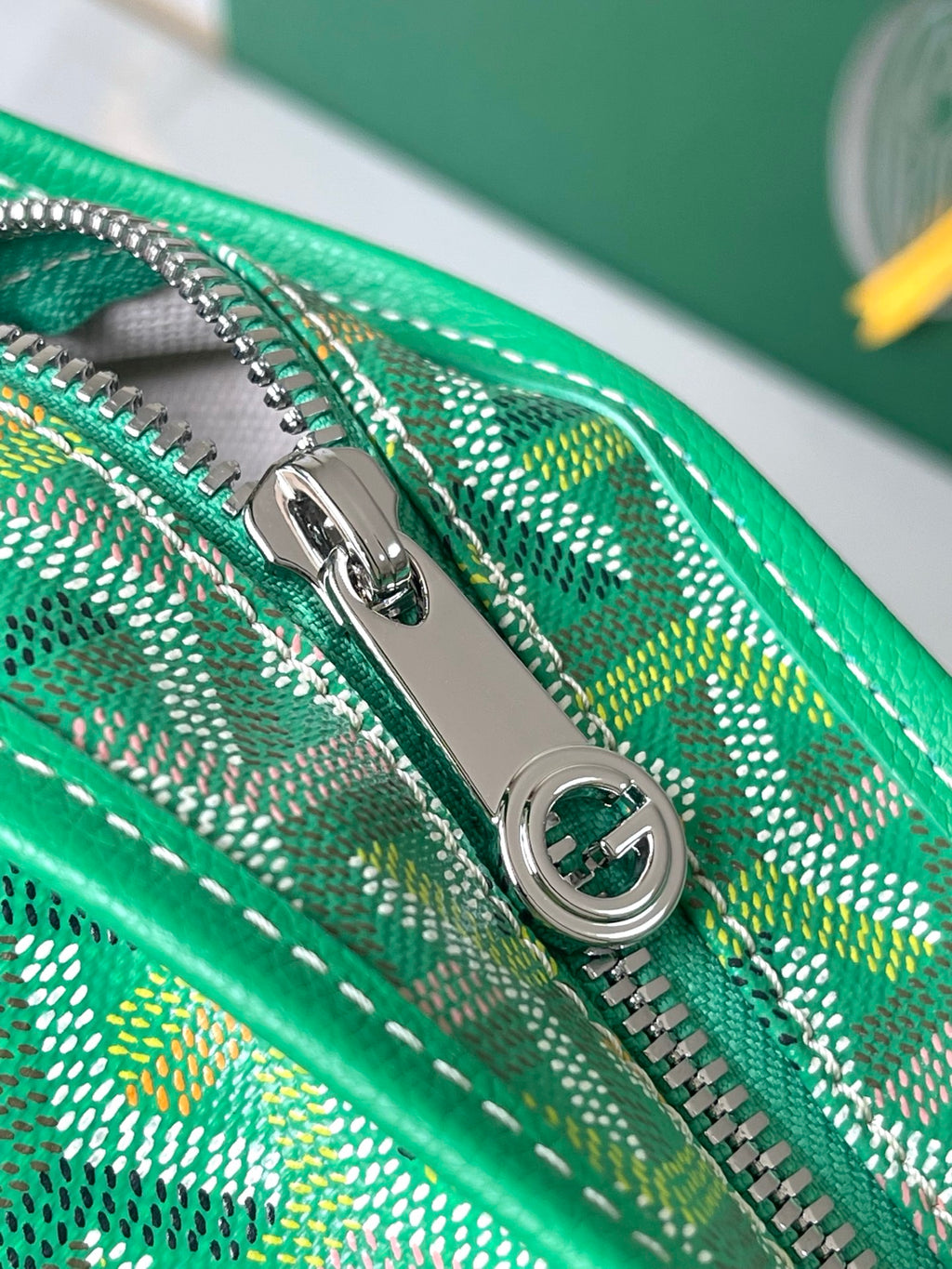 Close-up of green patterned zipper track and silver zipper pull