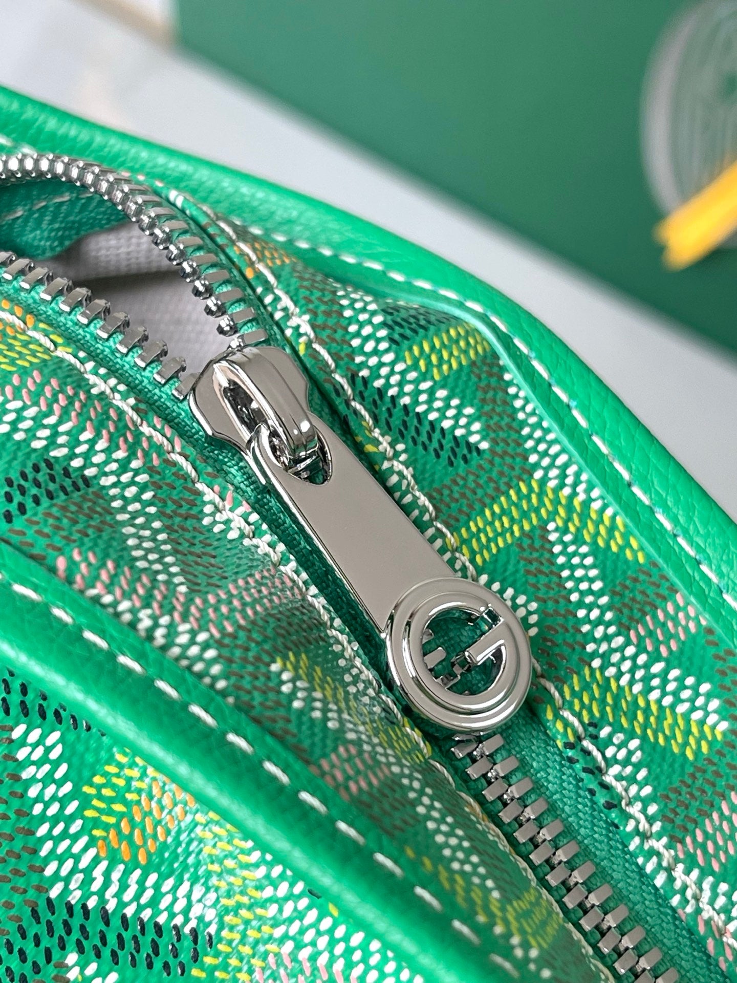 Close-up of green patterned zipper track and silver zipper pull