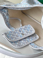 Light blue and white Goyard-pattern bag interior with zipper pocket and open compartments.