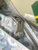 Light blue and white Goyard-pattern bag zipper with metal pull and circular emblem pull.