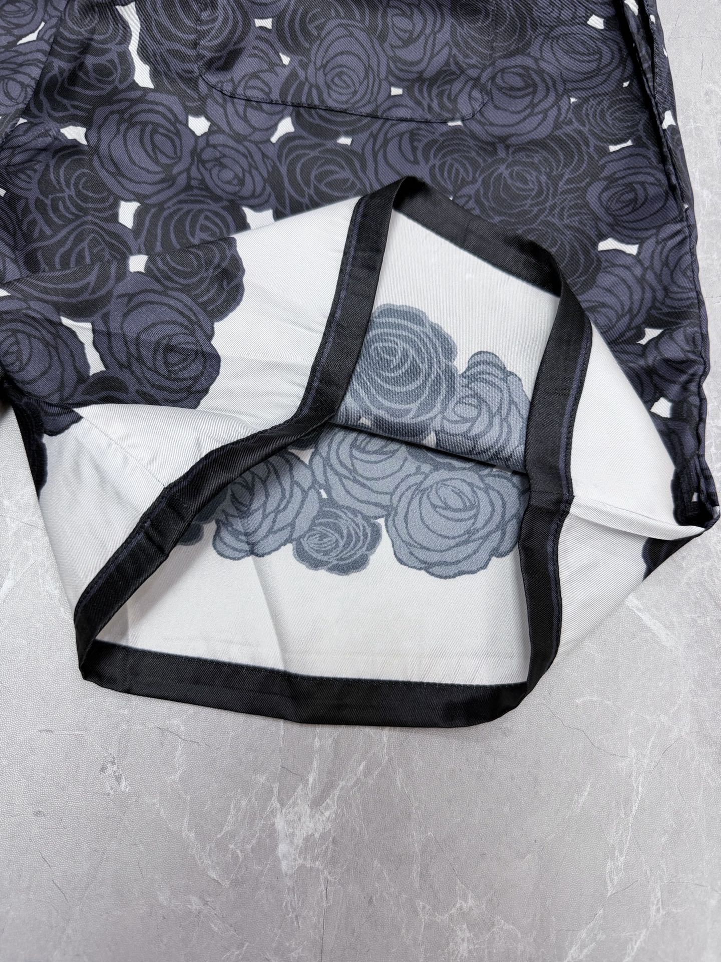 Navy shorts with white and light-blue rose print, black-trimmed interior panel