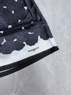 Navy shorts with white rose pattern, black-trimmed hem, and GIVENCHY label