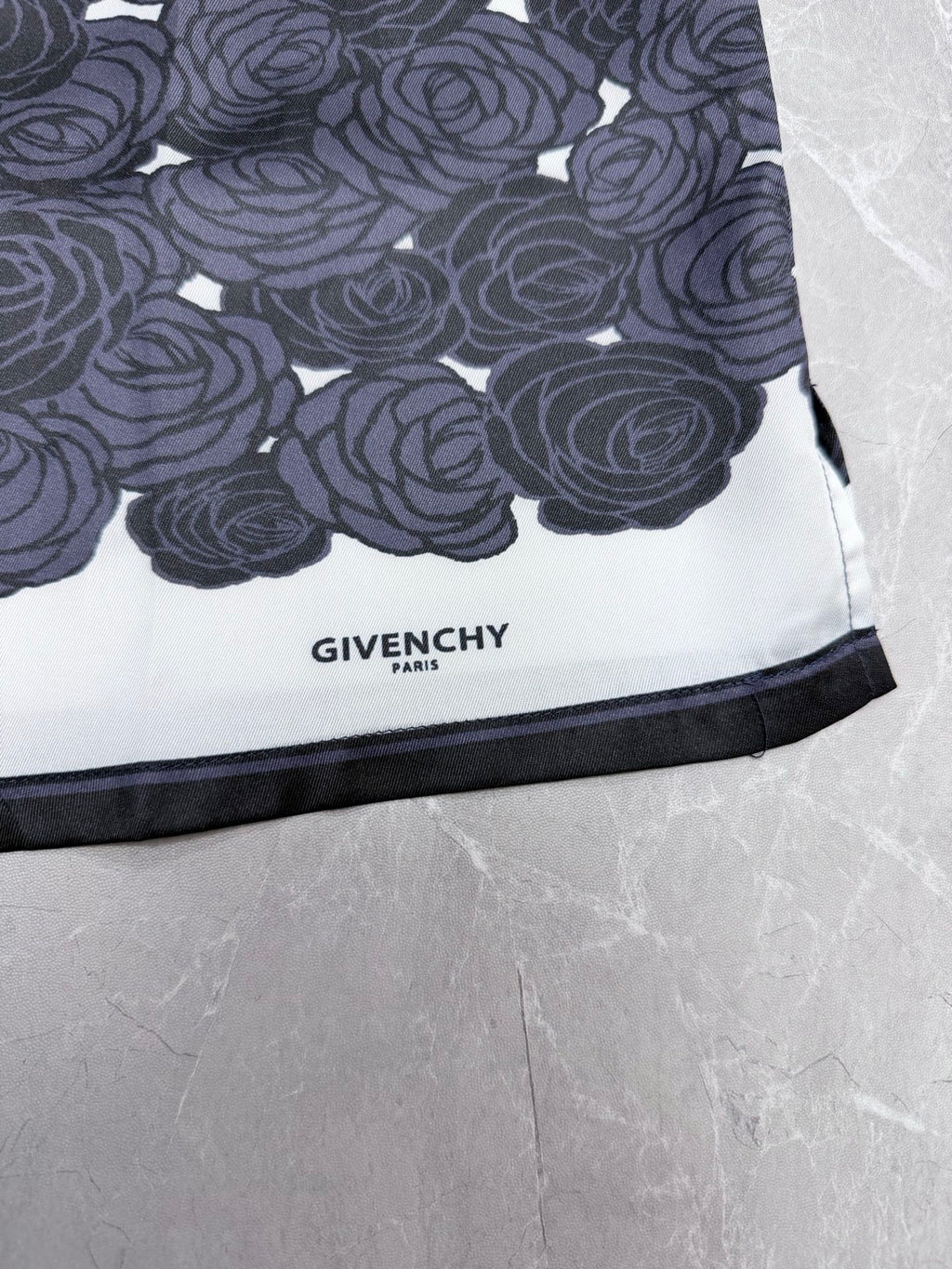 Givenchy "GIVENCHY PARIS" label on dark rose-pattern shirt hem with black trim