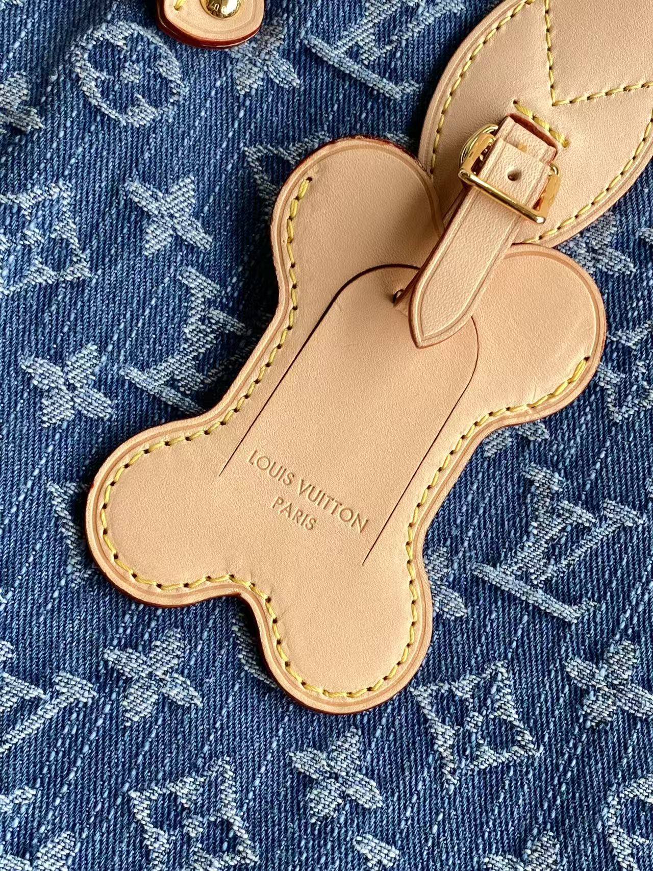 Louis Vuitton monogram bag charm shaped like a clover on blue fabric