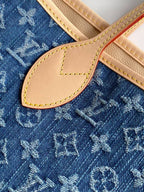 Close-up of Louis Vuitton monogram fabric with tan leather flap and stitched edge