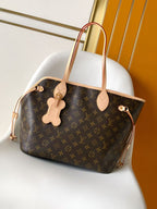 Louis Vuitton monogram tote bag with light tan leather handles and dangling charm