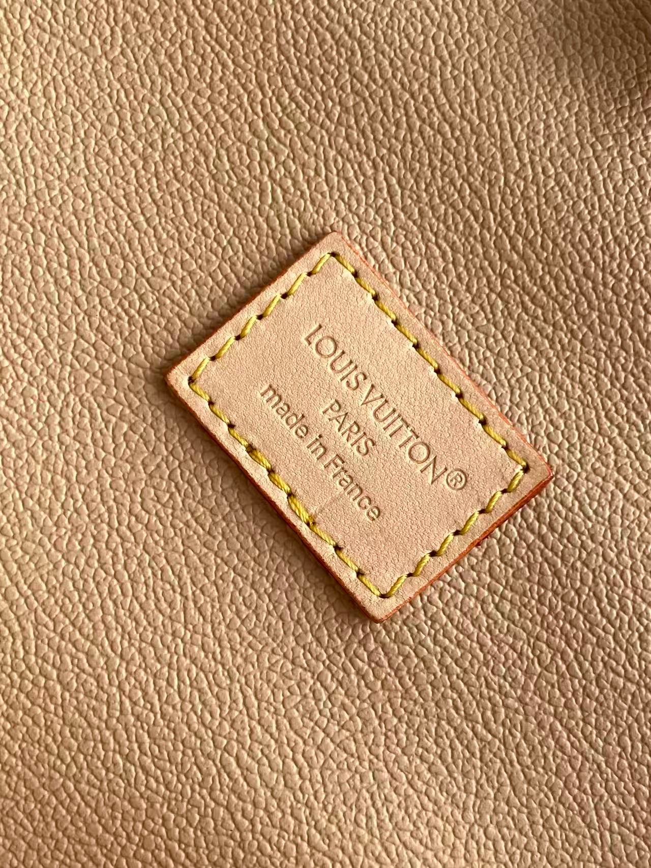 Louis Vuitton leather brand patch reading “Louis Vuitton” and “Made in France”