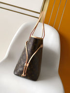 Louis Vuitton monogram tote bag side view with light tan shoulder straps
