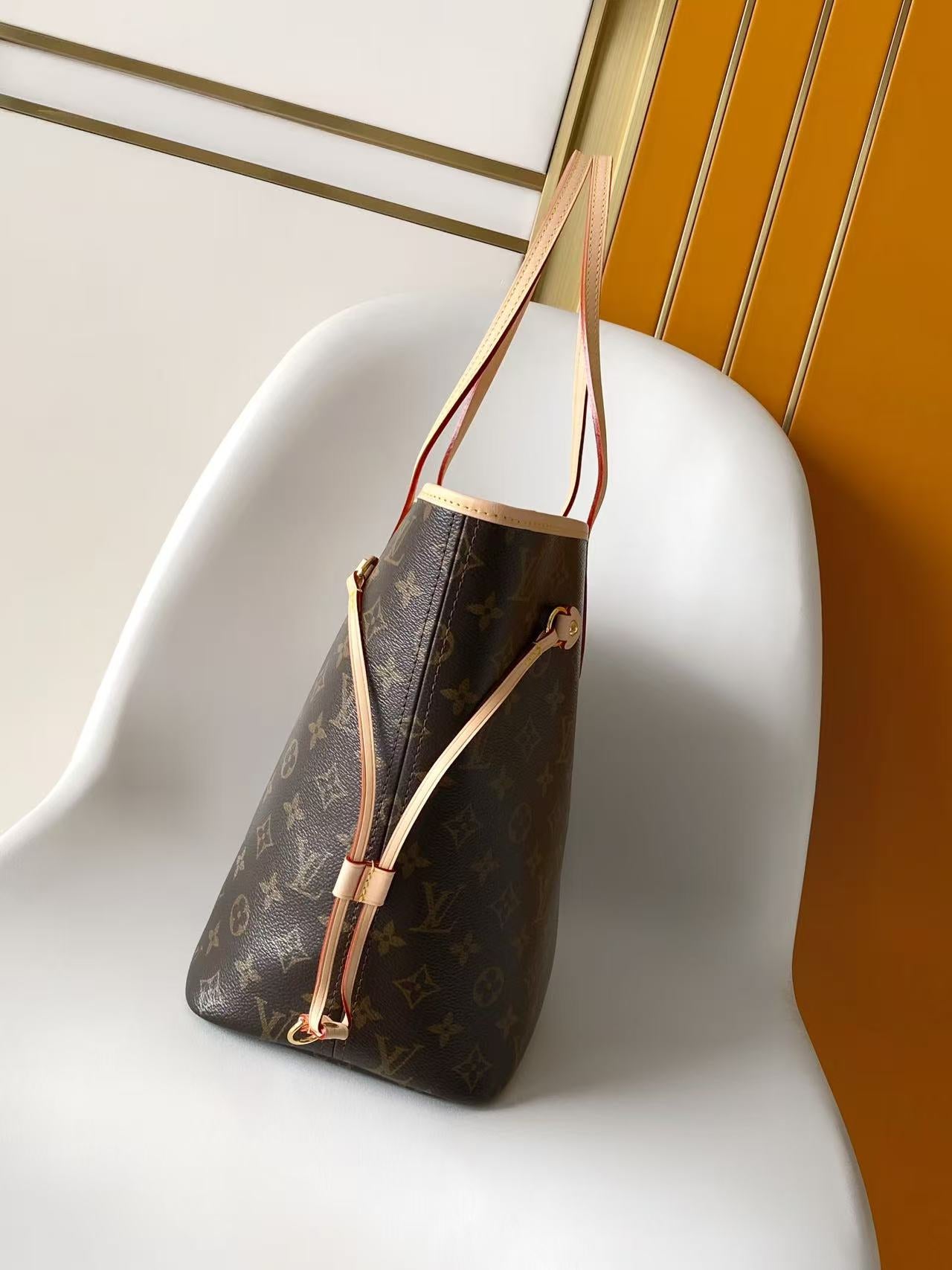 Louis Vuitton monogram tote bag side view with light tan shoulder straps
