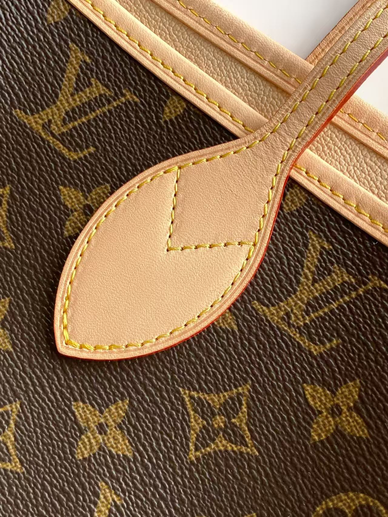 Louis Vuitton monogram tote bag close-up of light tan leather trim and stitching