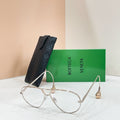 Silver-tone sunglasses with light-tinted lenses on a display stand