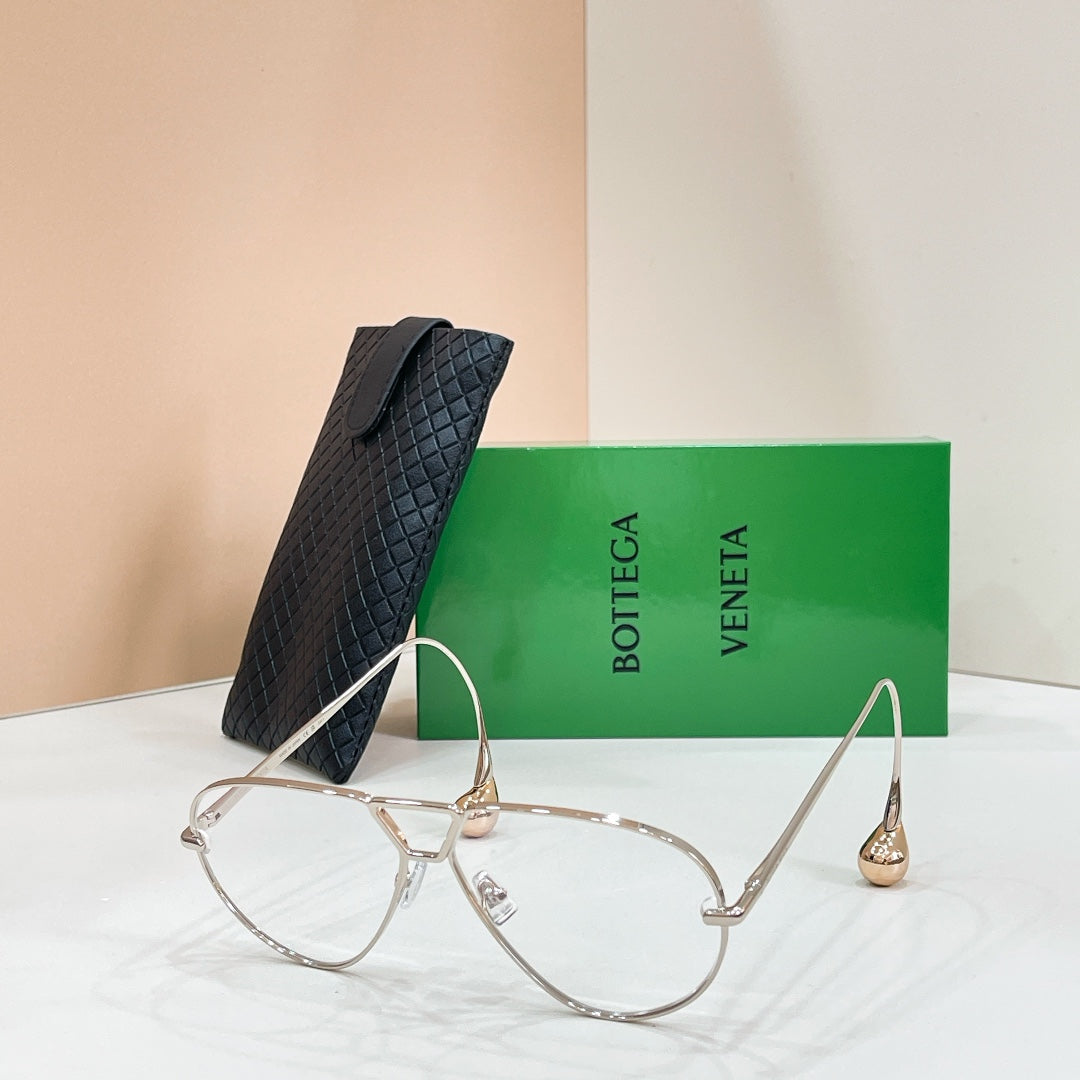 Silver-tone sunglasses with light-tinted lenses on a display stand
