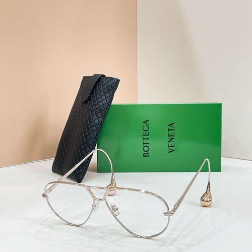 Silver-tone sunglasses with light-tinted lenses on a display stand