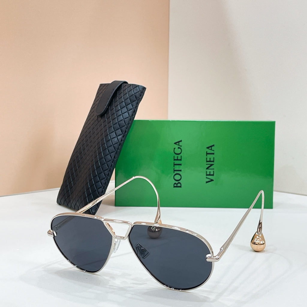 Silver-tone sunglasses with dark blue-tinted lenses on a display stand